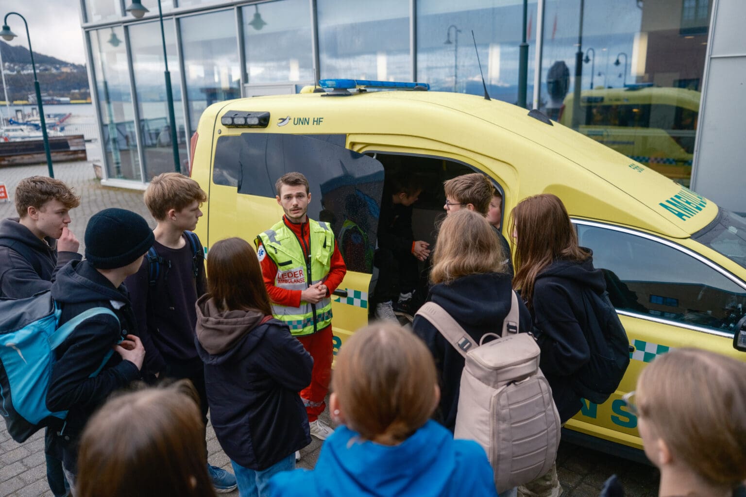 Ambulansesjåfør som forteller om yrket og viser frem ambulansen til ungdommer på Fremtidsdagen.